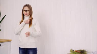 Young woman pointing indoors. Home vacation portrait. Blogger selfie video.