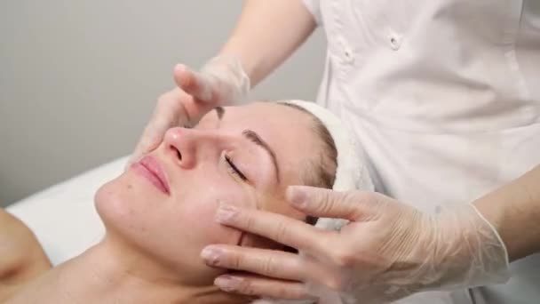 Masaje facial en el salón de spa. Médico manos. Una paciente bastante femenina. Tratamiento de belleza — Vídeo de stock