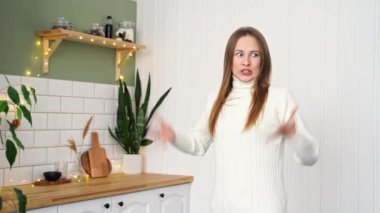 Mutfakta poz veren genç bir kadın. Ev tatili portresi. Günlük videosu