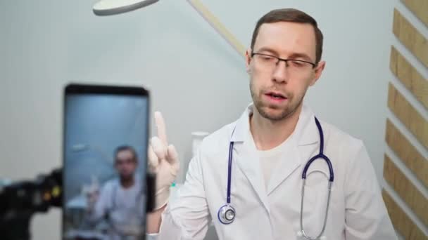 El doctor habla con el paciente por teléfono. Contenido de video de telemedicina. Blogger terapeuta — Vídeos de Stock
