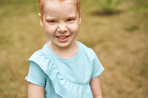 Klein meisje outdoor portret. Rood haar. Gelukkig babygezichtje. Vrouwelijke persoon — Stockfoto