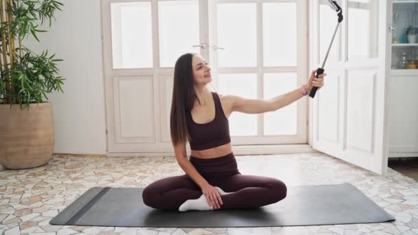 Mladá žena dělá autoportrét na podložce na jógu. Portrét domácí dovolené. Blogger — Stock video