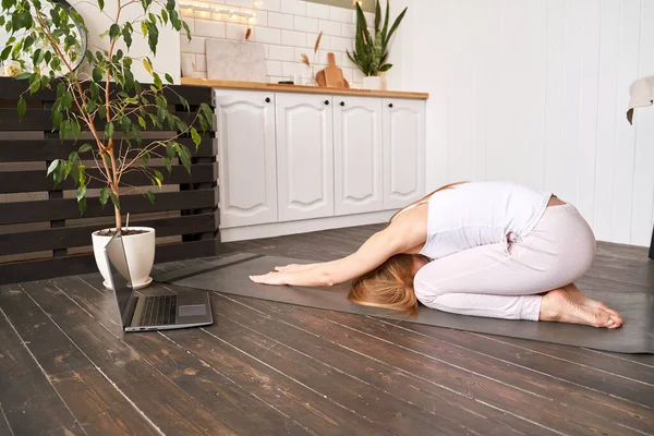 Jovem fazendo exercício de ioga em casa. Aulas online de cuidados de saúde. Balasana — Fotografia de Stock