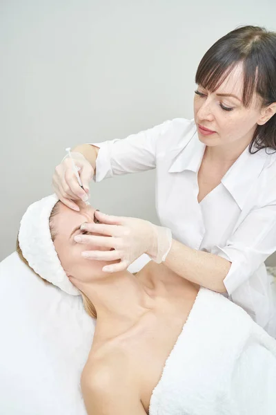 Iniezione al centro benessere. Medico con i guanti. Primo piano. Bella paziente femminile — Foto Stock