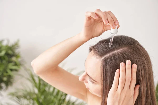 Ung kvinna hårbehandling. Argan olja hälsosam massage. Morgon badrum rutin Royaltyfria Stockbilder