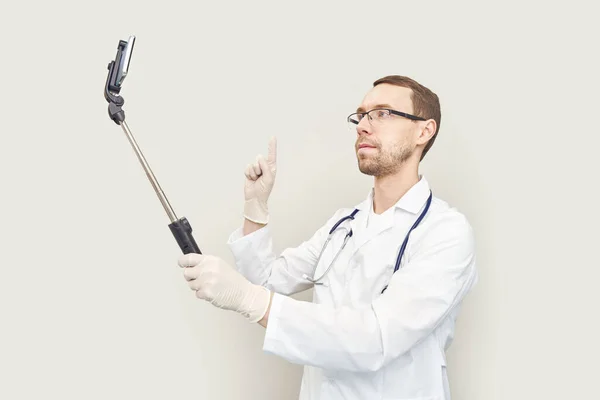 Doctor usando selfie telefónico. Dispositivo hospitalario. Examen online del paciente —  Fotos de Stock