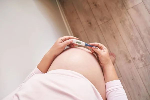 Schwangere mit Fieberthermometer. Grippebehandlung. Der Körper des Menschen. Krank Stockbild