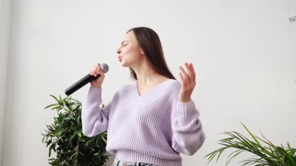 Mladá žena zpívá doma. Karaoke černý mikrofon. House lyrics dance. — Stock video