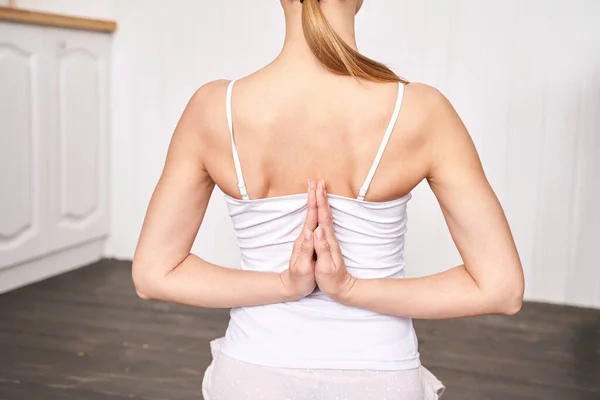 Mujer joven haciendo ejercicio de yoga en casa. Cursos en línea de atención médica. De interior — Foto de Stock