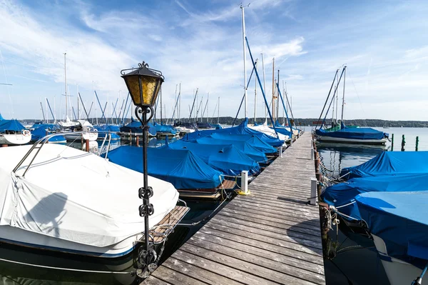 Barcos cubiertos y yates atracados en muelle de madera — Foto de Stock