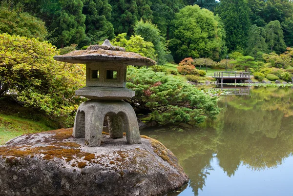 Lanterna antiga na lagoa no jardim japonês — Fotografia de Stock