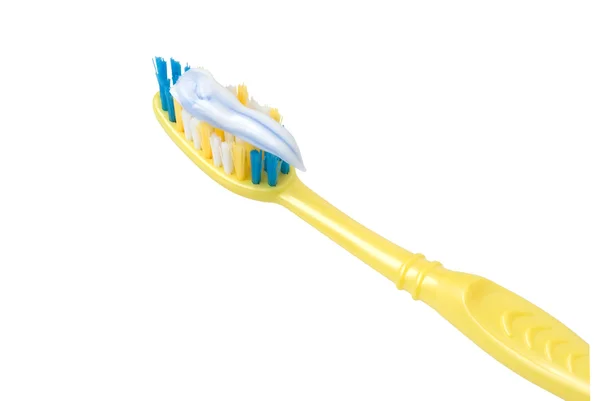 Yellow toothbrush coated with a toothpaste — Stock Photo, Image