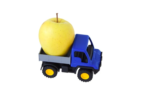 Желтое яблоко на заднем сиденье игрушечной машины — стоковое фото