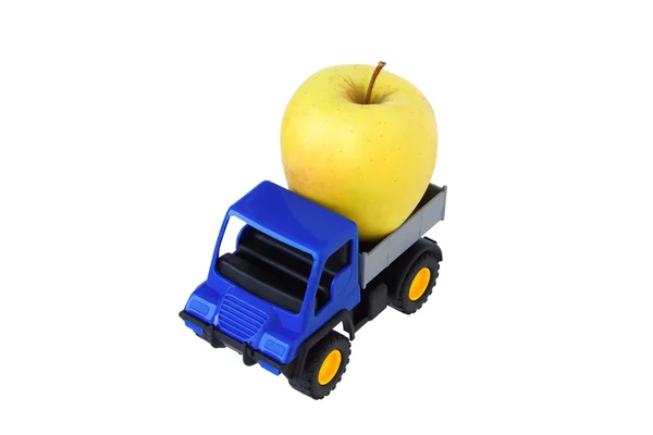 Yellow apple in the back of the toy car. — Stock Photo, Image