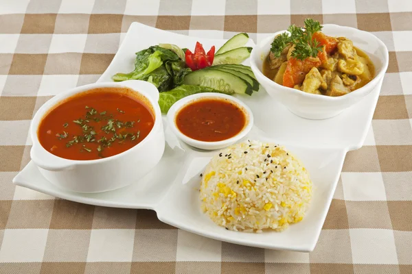 Curryhuhn, ein indisches Gericht, serviert mit Suppe und Reis mit Schneideweg. — Stockfoto