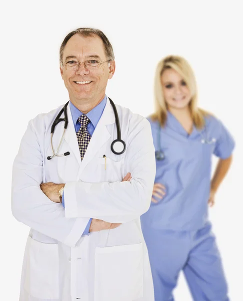 Un grupo de médicos y enfermeras confiados con los brazos cruzados mostrando cierta actitud y sonriendo aislados sobre un fondo blanco — Foto de Stock