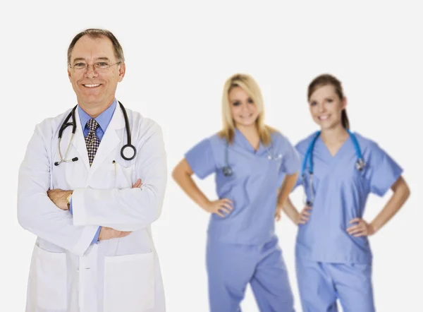 Un grupo de médicos y enfermeras confiados con los brazos cruzados mostrando cierta actitud y sonriendo aislados sobre un fondo blanco —  Fotos de Stock