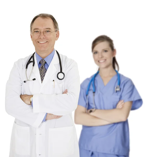 Un grupo de médicos y enfermeras confiados con los brazos cruzados mostrando cierta actitud y sonriendo aislados sobre un fondo blanco — Foto de Stock