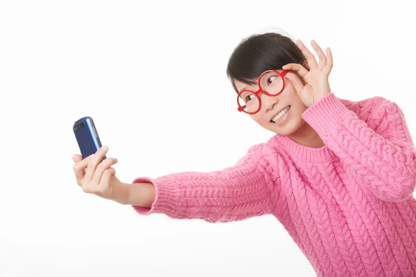 Hermosa mujer asiática usando un teléfono celular para tomar una selfie aislada sobre un fondo blanco — Foto de Stock