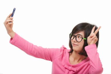 Beyaz bir arka plan üzerinde izole bir selfie almak için bir cep telefonu kullanarak güzel Asyalı kadın