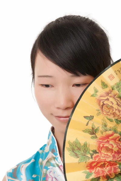 Beautiful Chinese woman wearing a cheongsam or chipao and posing with a fan isolated on a white background — Stockfoto