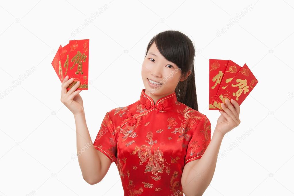 Beautiful Chinese woman holding a red envelope used to give a gift of money for the Chinese New Year and isolated on a white background