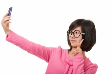 Beyaz bir arka plan üzerinde izole bir selfie almak için bir cep telefonu kullanarak güzel Asyalı kadın