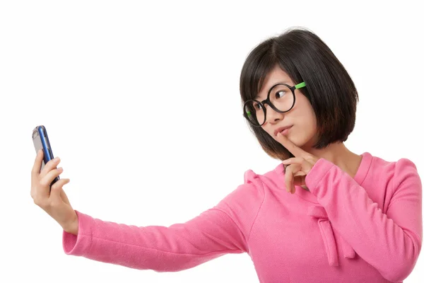 Hermosa mujer asiática usando un teléfono celular para tomar una selfie aislada sobre un fondo blanco — Foto de Stock