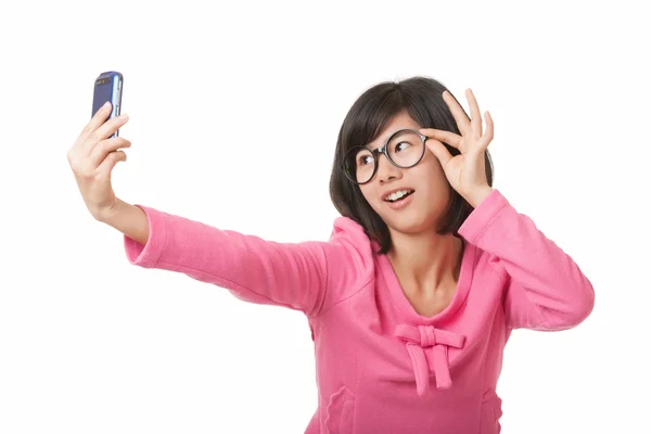 Gyönyörű ázsiai nő használ egy sejt telefon-hoz fog egy selfie elszigetelt fehér background — Stock Fotó