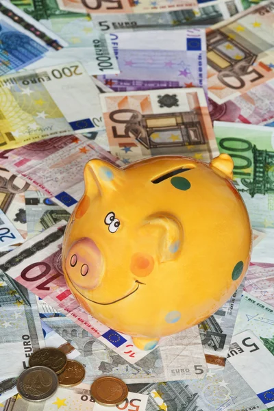 Billetes de banco en euros con una alcancía que ilustra el éxito — Foto de Stock