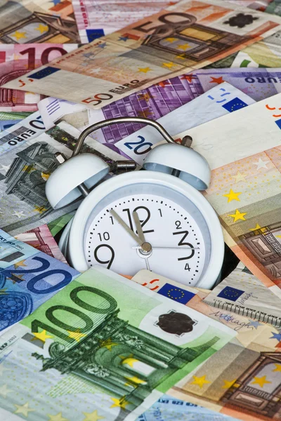 Zdjęcie wyświetlone czas to pieniądz z banknotów euro i zegar — Zdjęcie stockowe