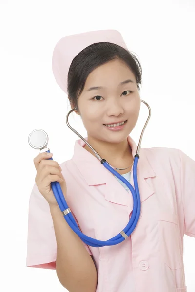 A portrait of a beautiful Asian nurse holding a stethoscope isolated on a white background — стокове фото