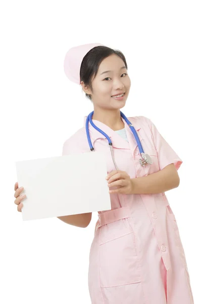 Linda enfermeira asiática segurando um sinal em branco isolado em um fundo branco — Fotografia de Stock