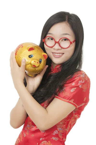 Mulher chinesa bonita vestindo um vestido tradicional conhecido como um Chipao segurando um banco porquinho isolado em um fundo branco — Fotografia de Stock