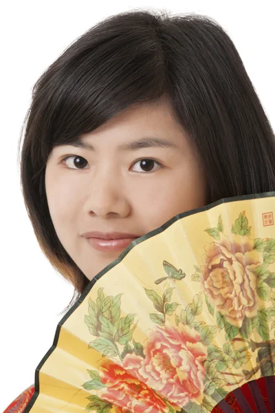 Красивая китаянка в чхонсам или чипао позирует с вентилятором, изолированным на белом фоне — стоковое фото