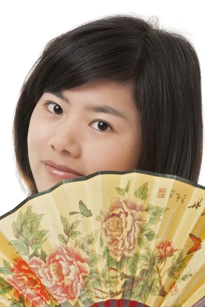 Beautiful Chinese woman wearing a cheongsam or chipao and posing with a fan isolated on a white background — ストック写真