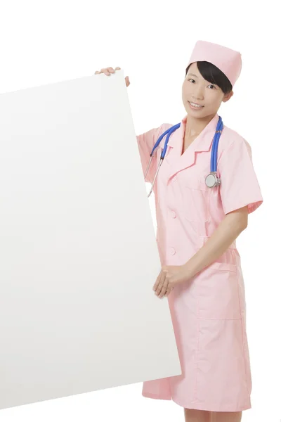 Beautiful Asian nurse holding a blank sign isolated on a white background — стокове фото