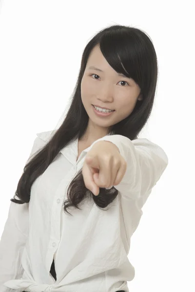Belle femme asiatique pointant du doigt la caméra isolée sur un fond blanc — Photo