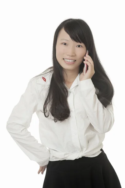 Una bella donna asiatica che parla su uno smartphone mentre è isolata su uno sfondo bianco — Foto Stock