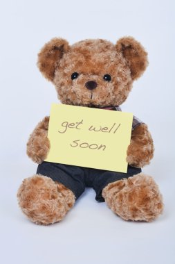 A cute teddy bear holding a yellow sign saying Get Well Soon isolated on a white background clipart