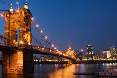 Cincinnati Ohio silueti Covington Kentucky 'den Ohio Nehri' nin karşısındaki John A Roebling süspansiyon köprüsü ile gece görüldü.