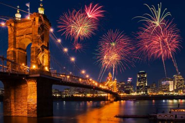 Güzel havai fişekler Cincinnati Ohio 'nun gece gökyüzünü dolduruyor. Covington Kentucky' den Ohio Nehri 'nin karşısına gece vakti John A Roebling Askı Köprüsü ile birlikte görülüyor.