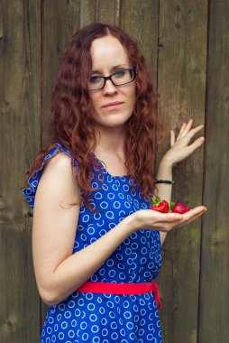 Kızıl saçlı kız çilek holding.