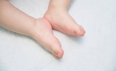 Tek kullanımlık beyaz bir bebeğin küçük ayakları yakın plan bebek bezi.