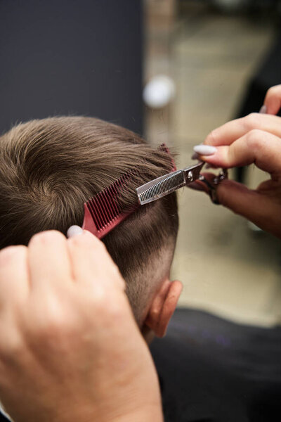 женщина парикмахер стрижет волосы маленького мальчика