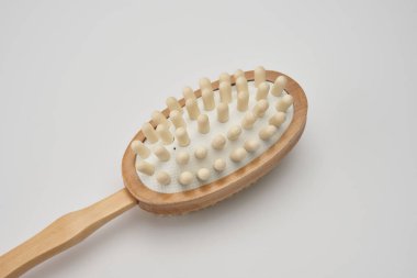 Beyaz arka planda doğal kılları olan kuru fırça masaj aleti.