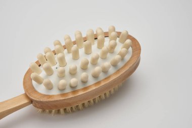 Beyaz arka planda doğal kılları olan kuru fırça masaj aleti.