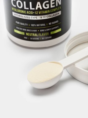 Rusya, naberezhnye chelny-01.15.2022: Kolajen takviyeli bir kavanoz ve hafif arkaplanda bir ölçüm kaşığı