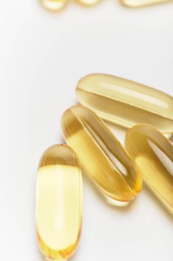 Beyaz arka planda sarı şeffaf tıbbi kapsüller