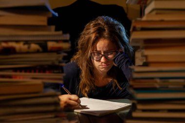 Sınavları için kütüphanede ders çalışan yorgun ve güzel bir kadın..